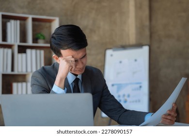 Young stressed Asian businessman working in the office. Businessman thinking too much work concept in the office. - Shutterstock ID 2278090157