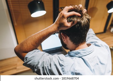 Young stressed businessman in a panic in front of a computer in office.
