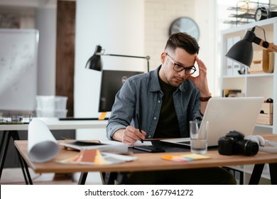 Young stressed handsome businessman working in office. Angry businessman with too much work in office. 