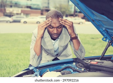 young stressed man having trouble with his broken car looking in frustration on failed engine 