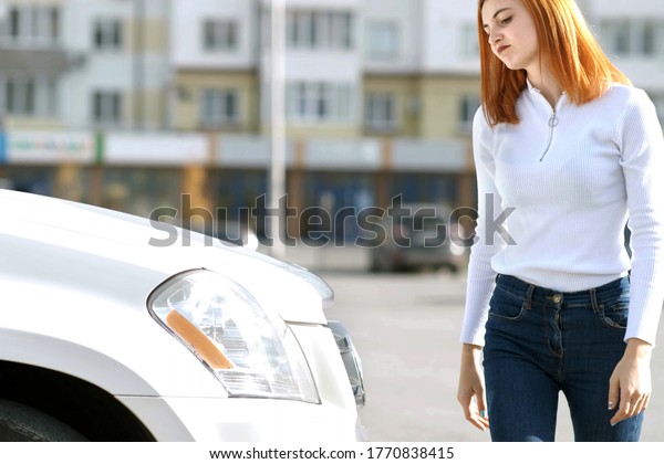 Young stressed\
woman driver near broken car having a prbreakdown problem with her\
vehicle waiting for\
assistance.