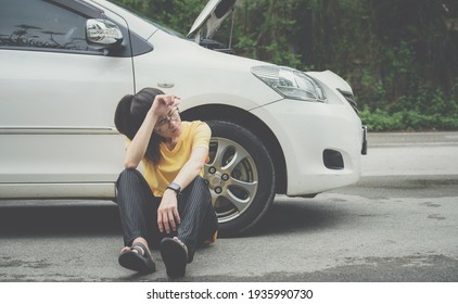 Young stressed woman having trouble with her car breakdown on the road and she waiting someone can help her. Conceptual of car accident on the road. 