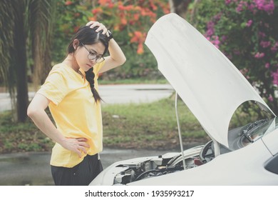 Young stressed woman having trouble with her car breakdown on the road and she waiting someone can help her. Conceptual of car accident on the road.