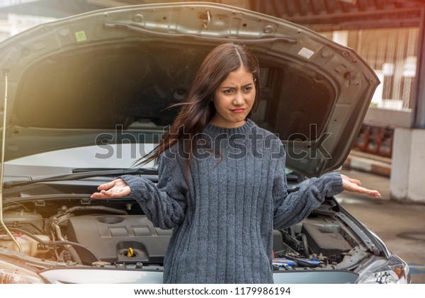 young stressed woman having\
trouble with his broken car need held in frustration at failed\
engine