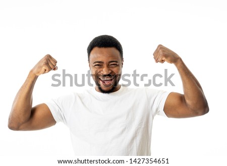 Similar – Cheerful man celebrating his success with a broad smile and raised fist in front of a neutral background