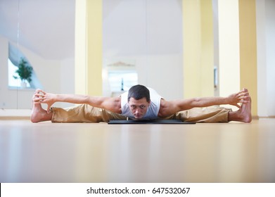 A young strong man doing yoga exercises -Samakonasana Straight angle pose  in the yoga studio - Shutterstock ID 647532067