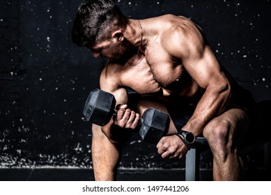 Young Strong Muscular Sweaty Fit Man Biceps Muscle Crossfit Workout Training With Heavy Dumbbell Weight In The Gym Dark Image With Shadows Real People