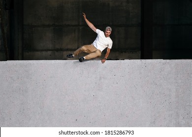 Young strong parkour and freerunning athlete jumping over the wall in urban environment. Copy space. Extreme sport and outdoor training concept - Powered by Shutterstock