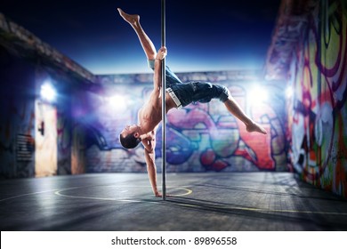 Young Strong Pole Dance Man On Urban Background.