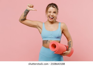 Young strong sporty athletic fitness trainer instructor woman wear blue tracksuit spend time in home gym point thumb finger herself isolated on pastel plain light pink background Workout sport concept - Powered by Shutterstock