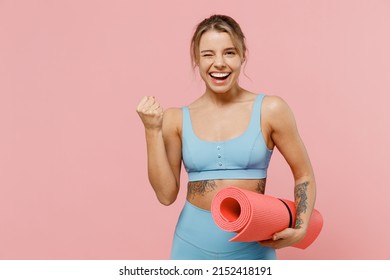 Young strong sporty athletic fitness trainer instructor woman wear blue tracksuit spend time in home gym do winner gesture clench fist isolated on pastel plain pink background. Workout sport concept - Powered by Shutterstock