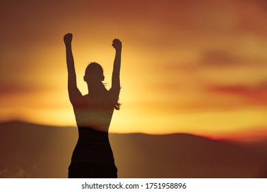 Young strong victorious woman with fist up to the sunset sky feeling positive, happy and determined.  - Shutterstock ID 1751958896