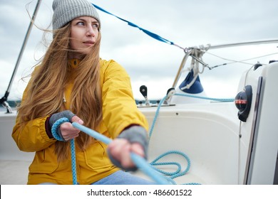 Young Strong Woman Pulling Rigs On The Sailboat