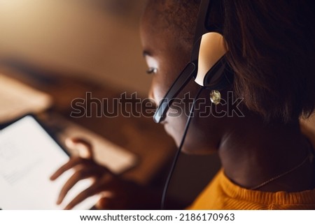 Young student browsing, learning online and searching the web at night on a tablet. Woman watching educational videos with headset, reading from the internet and participating in an online class