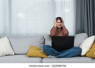 Young Student Or Business Woman Sitting At Home Covering Her Ears With Hands Because She Cant Study Or Work On Her Laptop Computer From Loud Noise Coming From Apartment Above. 