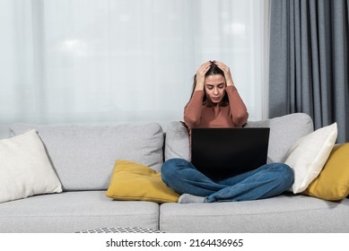 Young Student Or Business Woman Sitting At Home Covering Her Ears With Hands Because She Cant Study Or Work On Her Laptop Computer From Loud Noise Coming From Apartment Above.