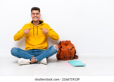 Young student caucasian man sitting one the floor isolated on white background with surprise facial expression