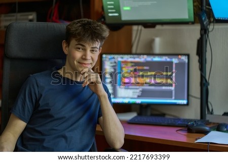 Young student learning computer science, coding, programming, IT classroom, system service administrator. Portrait of teenage boy.