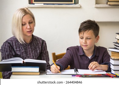 Young student learns at home with a his mom tutor.