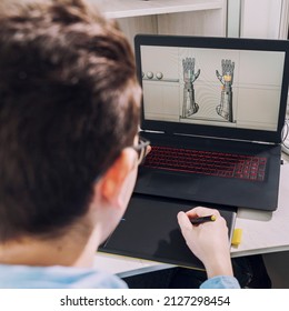 Young student male 3D designer uses graphics tablet to work at his desk. development of 3d characters for online games.