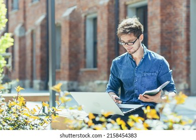 A Young Student Outside On Campus Is Studying On A Bench, A Man With A Laptop Is Studying Online Remotely