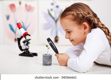 Young student studies small plant in elementary science class