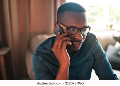 Young Student Talking On A Phone Call To A Friend, Colleague Or Family Member. Black Male University Or College Learner Studying Design, Marketing Or Architecture Sitting And Chatting At Home