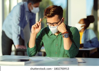 Young student wearing protective face mask and thinking while doing an exam in the classroom. 