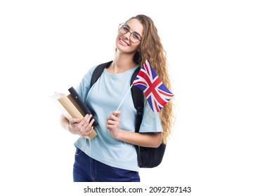 Young Student Woman In Glasses With Backpack Holding An United Kingdom Flag Isolated On White Studio Background 