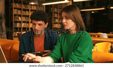Young students collaborating on project in university library colleagues working in modern coworking. Online technology concept