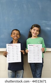 Young Students Holding Spelling Tests With Good Grades. Vertically Framed Shot.