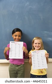 Young Students Holding Spelling Tests With Good Grades. Vertically Framed Shot.