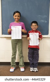 Young Students Holding Spelling Tests With Good Grades. Vertically Framed Shot.