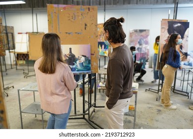 Young Students Painting Inside Art Room Class At College - Focus On Guy Head