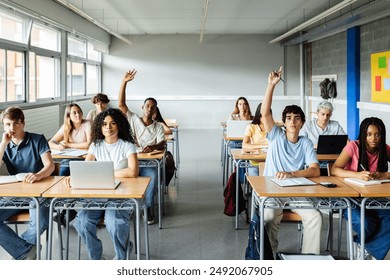 Young students raising hands to ask a question during lecture at high school classroom. Education and back to school concept. - Powered by Shutterstock