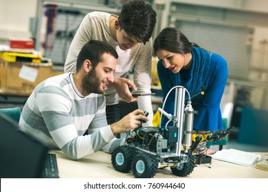 Young students of robotics preparing robot for testing in workshop - Powered by Shutterstock