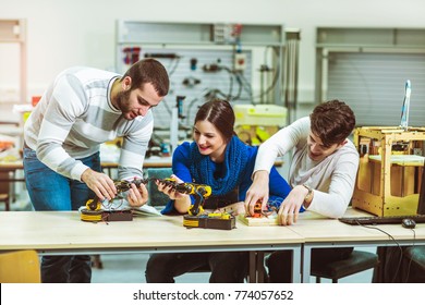 Young students of robotics preparing robot for testing in workshop - Shutterstock ID 774057652