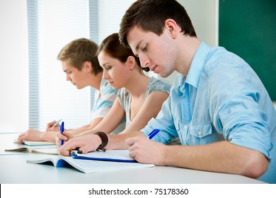 young students studying together in a classroom - Powered by Shutterstock