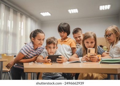 Young students use cellphone for video games on a break in the classroom at school - Powered by Shutterstock