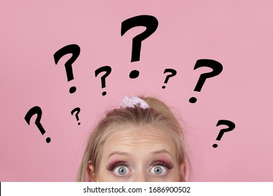 
Young Stupid Blonde Woman Asking Questions With Question Marks On Pink Isolated Background