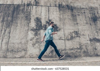 Young Stylish Bearded Man Is Rushing To The Meeting. He Is In A Casual Outfit, With Glasses, Walking Outside