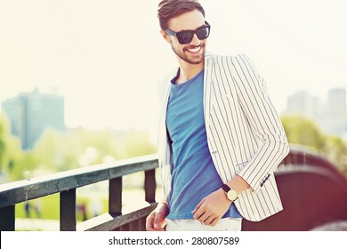 Young stylish confident happy handsome businessman model  in suit hipster cloth lifestyle in the street standing near wall