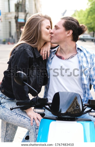 Young\
stylish couple with a motorcycle on a city\
street