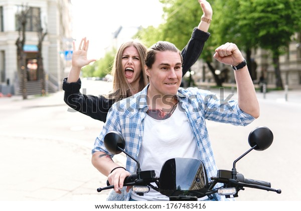 Young\
stylish couple with a motorcycle on a city\
street
