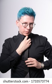 Young Stylish European Man Adjusts His Bright Blue Hair And Skinny Tie, Waist Deep Photo In A Studio