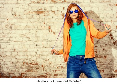 Young stylish girl in the city. Brick wall background. Youth fashion. Hip-hop style. - Powered by Shutterstock