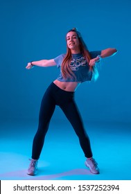 Young Stylish Girl Dancing Zumba In The Studio On A Colored Neon Background. Dance Poster Design.