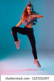 Young stylish girl dancing zumba in the Studio on a colored neon background. Dance poster design.