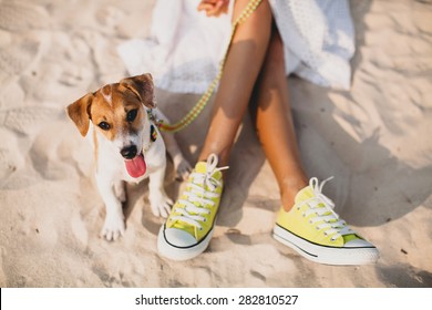 young stylish hipster woman playing dog puppy jack russell in tropical beach, cool outfit, romantic mood, having fun, sunny, horizontal, vacation, lying on the sand, shoes close up - Powered by Shutterstock