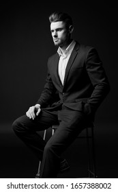 young stylish man with a beard. A man in a classic suit. Male portrait on a black background. Monochrome photo. Male model. Studio business portrait.